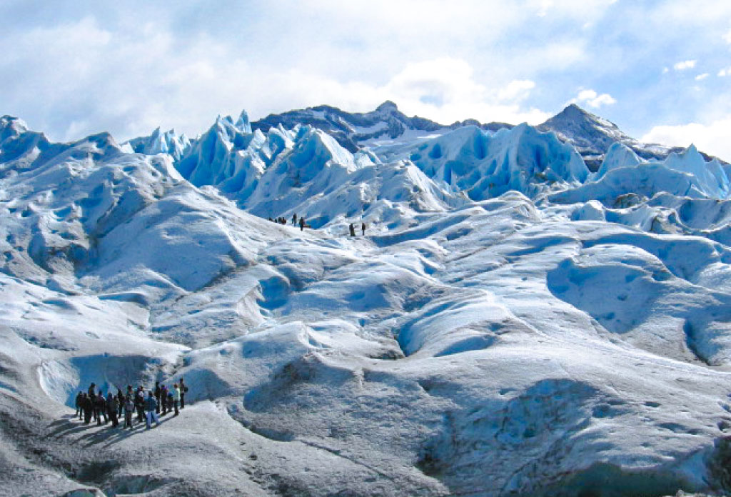 Image du glacier Perito Moreno avec plusieurs groupes de personnes marchant dessus