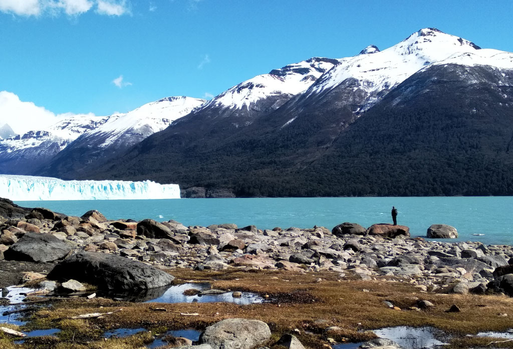 un homme en face du lac argentino et glacier perito moreno en patagonie argentine