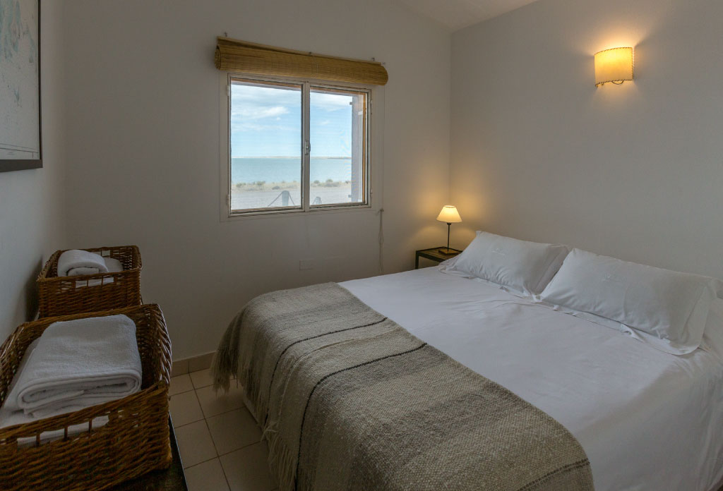 chambre avec un lit et une fenêtre avec vue à l'ocean. C'est le lodge bahia bustamante