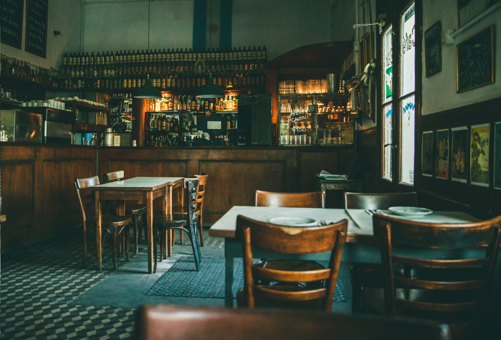 image du bar Flor de Barracas avec des tables et la barre avec boissons. C'est l'un des bars notables.