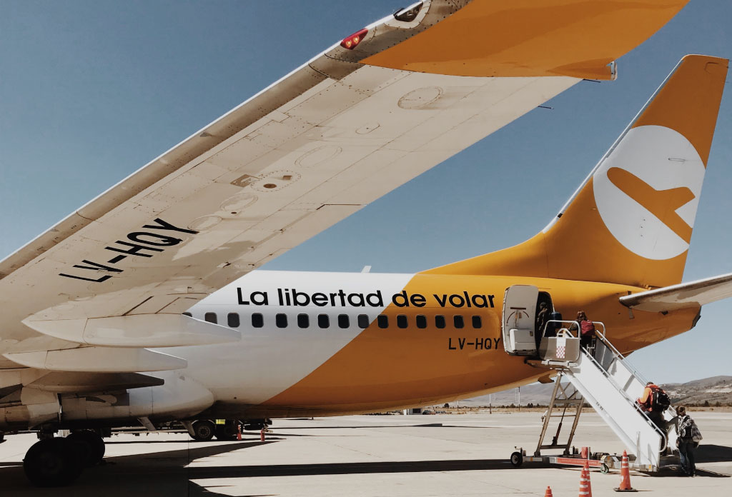 avion Flybondi stationné à l’aéroport. Il y a des gens qui montent dans l’avion. C’est l’une des compagnies aériennes Low Cost en Argentine.