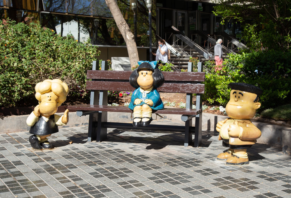 Statue de Mafalda assise sur un banc et à côté des amis