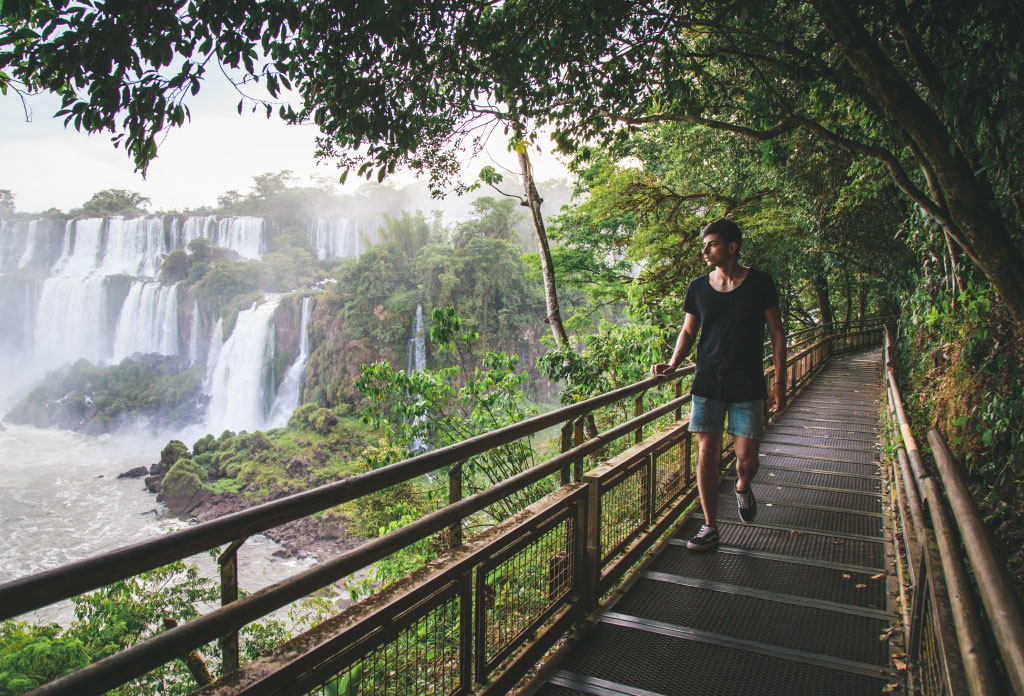 une personne se promène sur les passerelles du Parc National Iguazu. À côté, vous pouvez voir les chutes d’eau. C'est l'une des activités qui font partie de que faire à Iguazu pendant 3 jours.