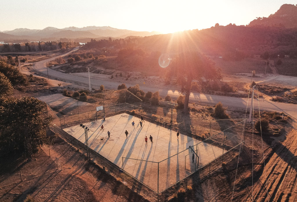 Groupe de personnes jouant au football au coucher du soleil