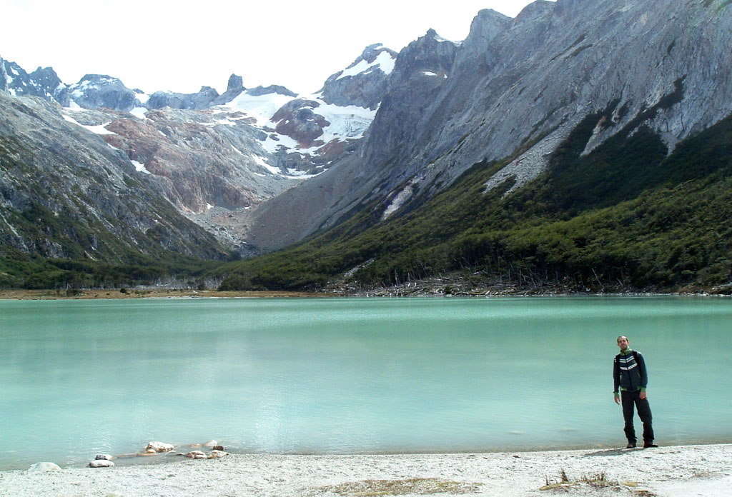 lac émeraude entourée de montagnes et une personne debout sur la droite de l’image