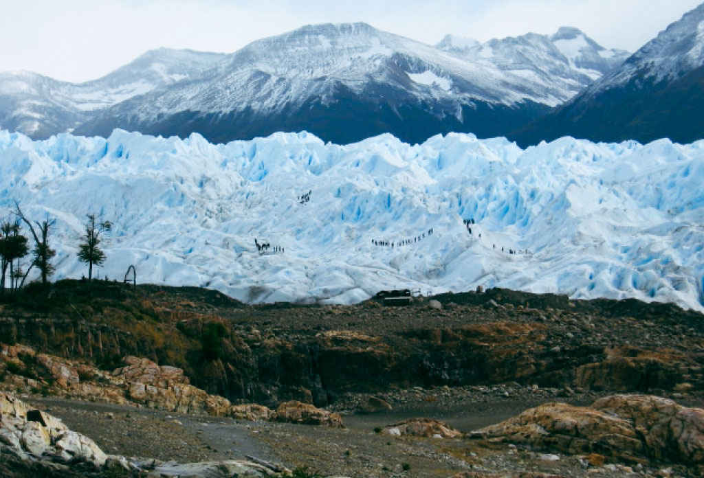 Image du glacier Perito Moreno avec plusieurs groupes de personnes marchant dessus