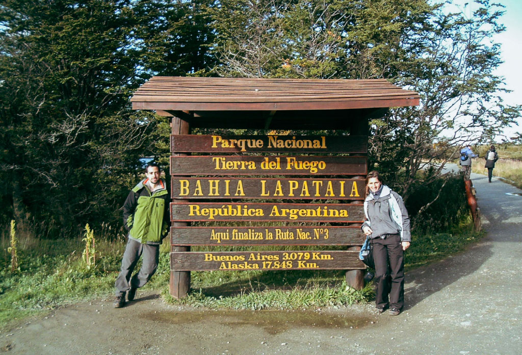 deux personnes à coté du celebre panneau de la fin de la route 3 panamericaine à Ushuaia