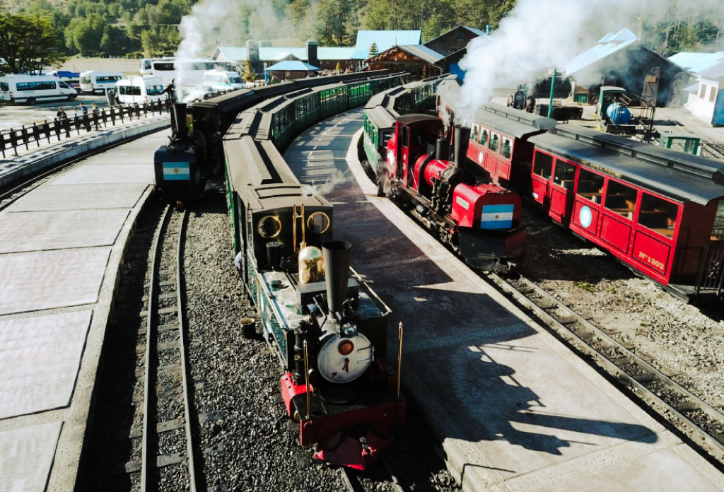 3 locomotives et plusieurs wagons verts et rouges de train du bout du monde