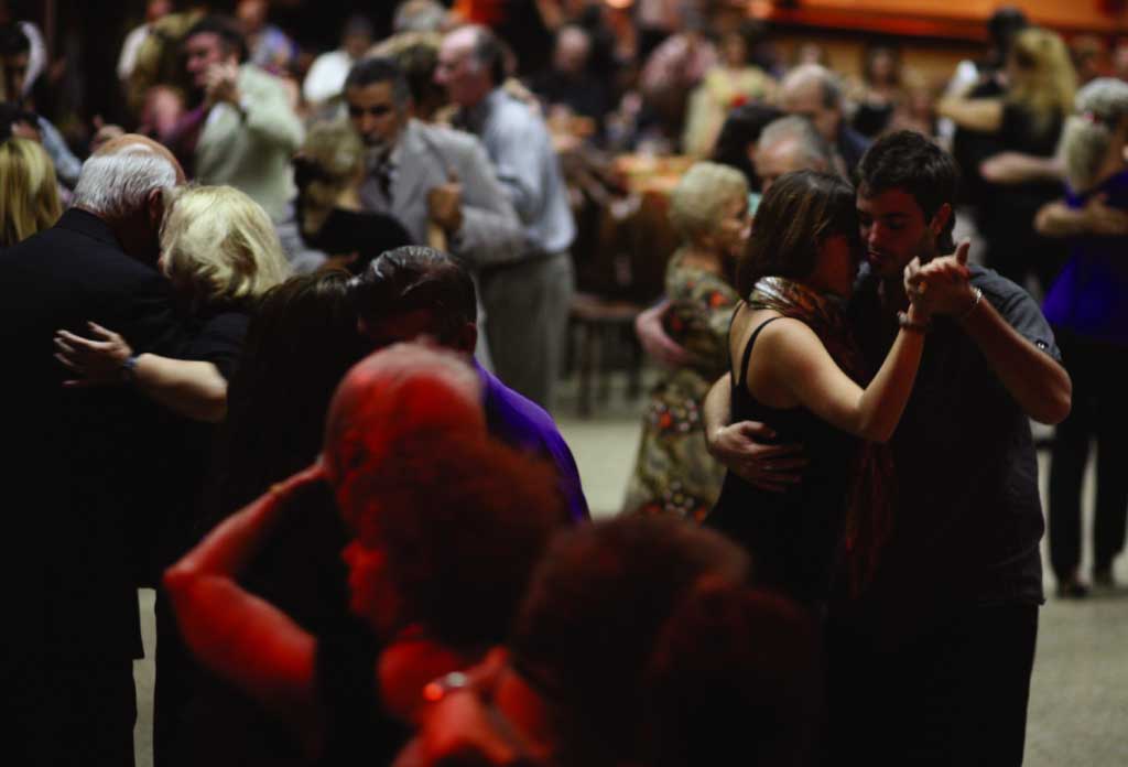 plusieurs personnes dansant le tango dans les bras les unes des autres