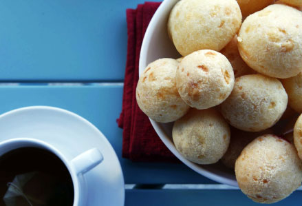 Plusieurs chipa sur une assiette et un café à côté