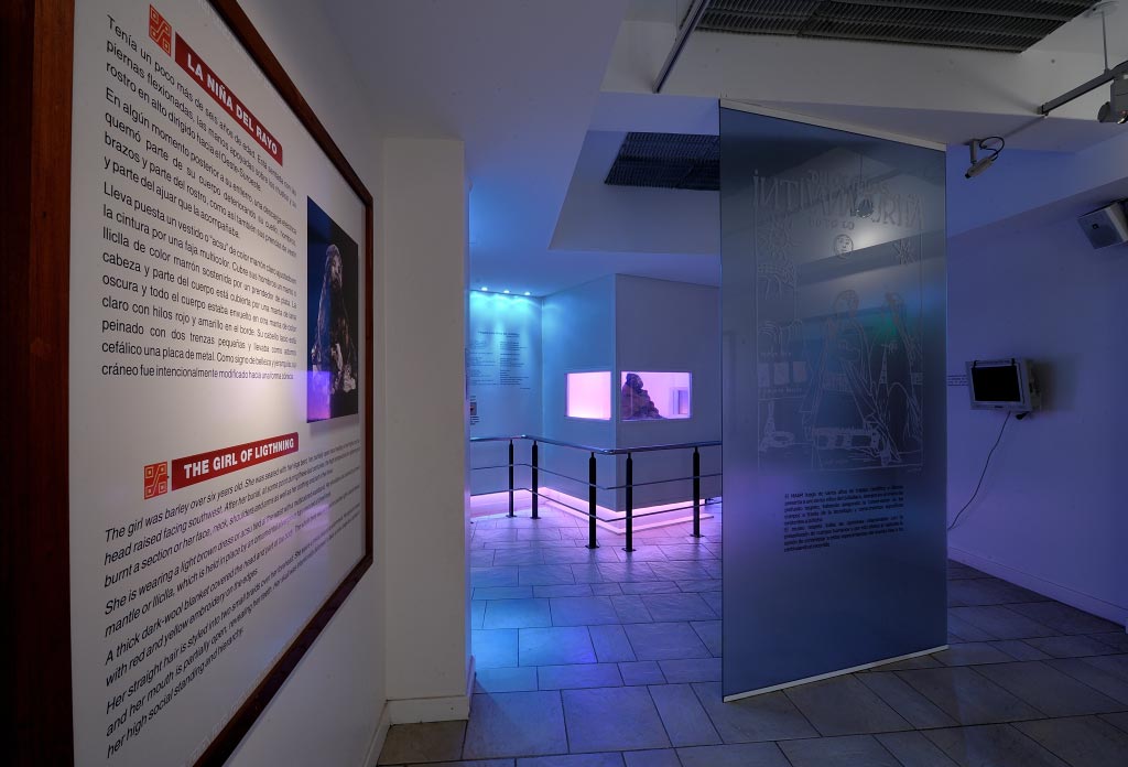 Salle du Musée d’Archéologie de Haute Montagne. Au fond on voit une capsule de verre avec une momie.