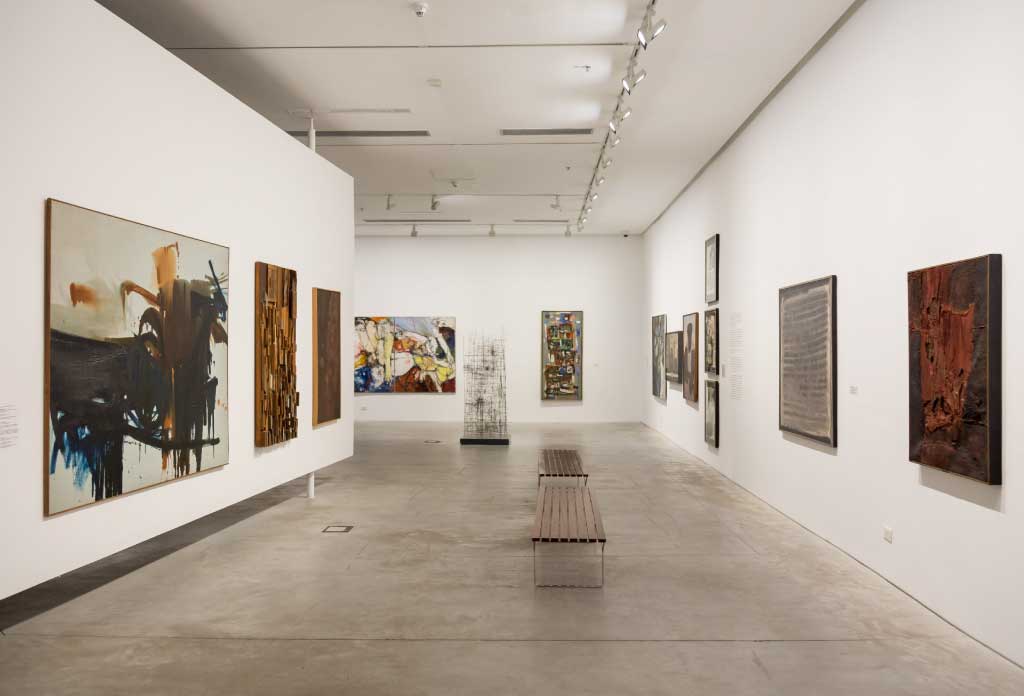 salle de musée avec plusieurs tableaux accrochés aux murs