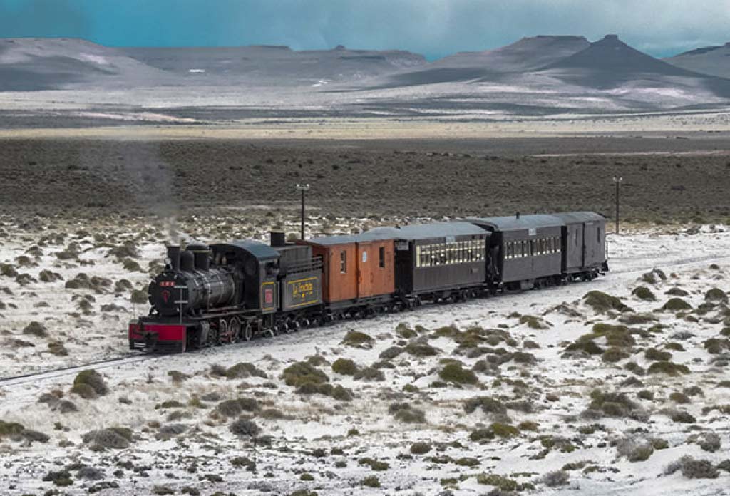 photo aérienne du train La Trochita en passant par la steppe patagonique avec de la neige