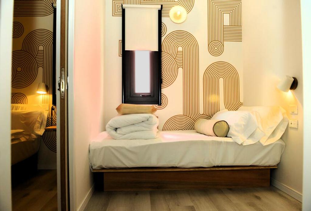 un lit avec une fenêtre dans un hôtel