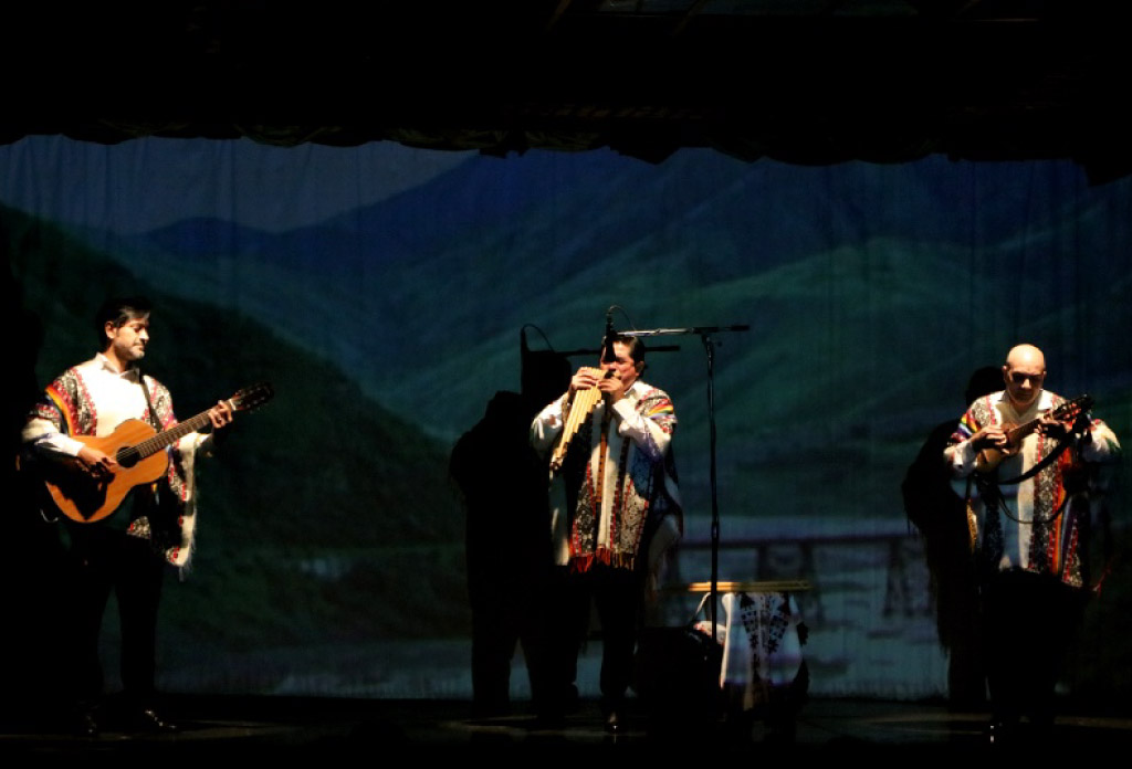 Trois personnes sur scène jouant des instruments de folklore argentin